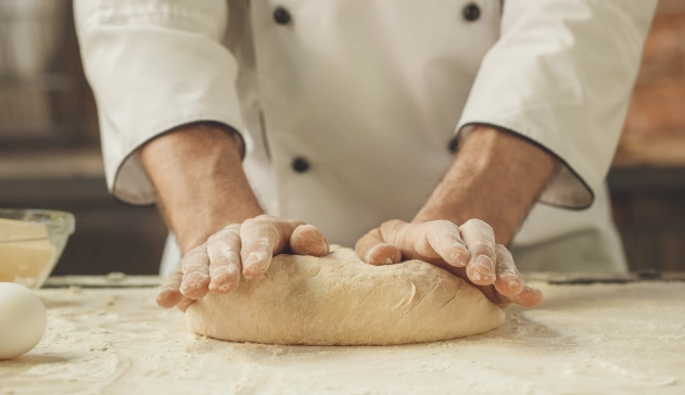 Pessoa solvando massa de pão